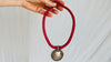 Antique Indian Silver Pendant on a Wrapped Red Cord.